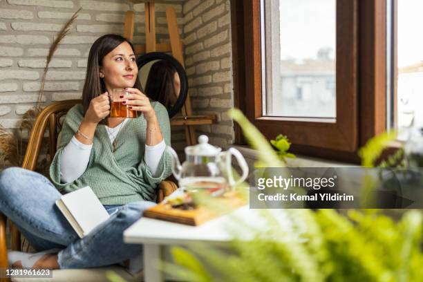 young woman drinking her winter tea and welcoming new day - ceremony stock pictures, royalty-free photos & images