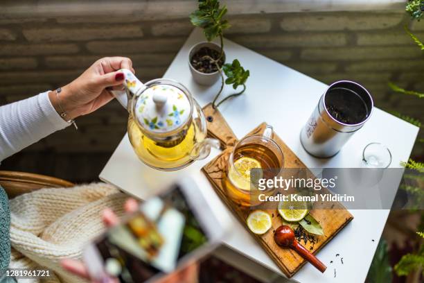 mujer joven de cerca tomando té de hierbas en la acogedora tienda de té - dried tea leaves fotografías e imágenes de stock