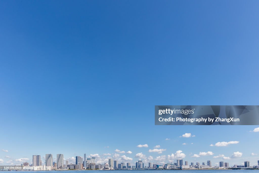 Tokyo skyline with residential and office buildings against clear blue sky, Japan.