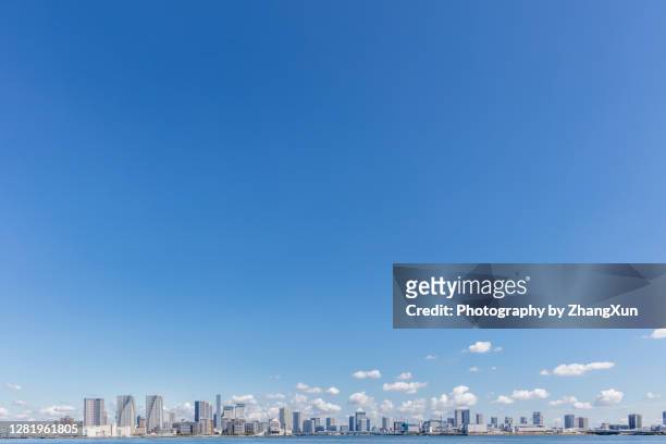 tokyo skyline with residential and office buildings against clear blue sky, japan. - tokyo street stockfoto's en -beelden