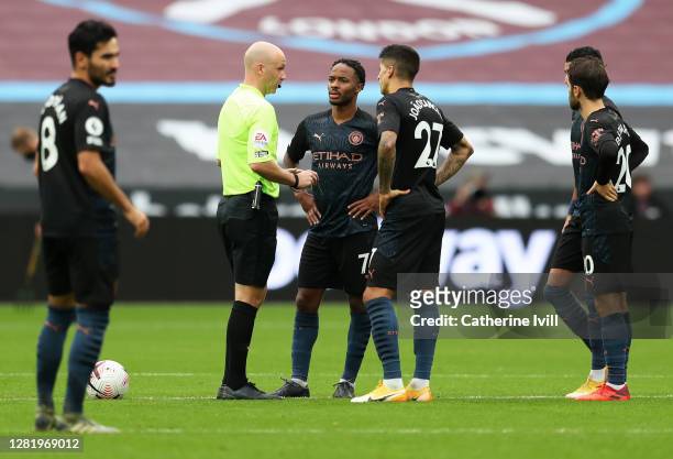 Raheem Sterling of Manchester City and Joao Cancelo of Manchester City speaks with match referee Anthony Taylor at the beginning of the second half...