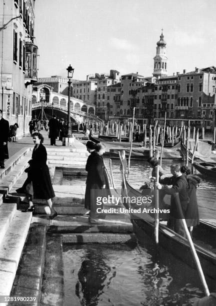 Travel to Venice - Italy in 1950s - water taxi and passengers at the Grand Canal , near Rialto Brige . Photo taken in 1954 by Erich Andres.