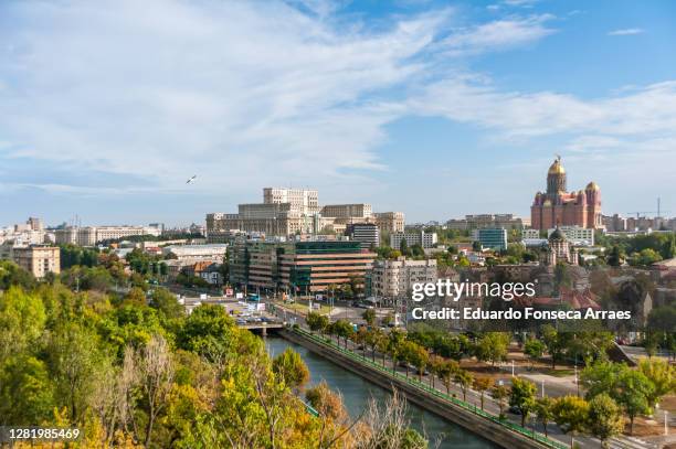 view of trees of a public park, the dâmbovița river, downtown buildings and the colossal romanian palace of parliament (palatul parlamentului) - 布加勒斯特 個照片及圖片檔