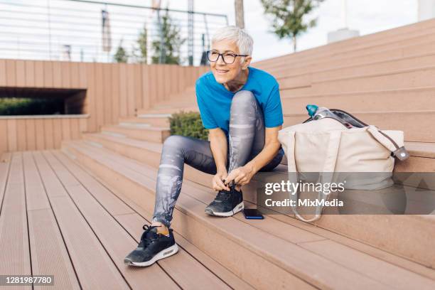 mujer mayor preparándose para su recreación al aire libre - gym bag fotografías e imágenes de stock