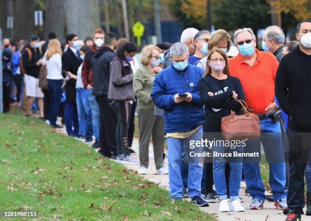 Residents wait in line for the opening of an early voting location at the Mid-Island Y Jewish Community Center on October 24, 2020 in Plainview, New...