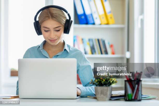 young woman sit at desk at home - translation stock pictures, royalty-free photos & images