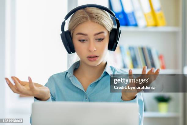 woman wearing headphones with microphone chatting online - epidemic sound stock pictures, royalty-free photos & images