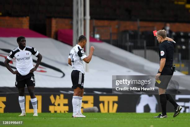 Referee Graham Scott awards Aboubakar Kamara of Fulham a red card following a VAR review during the Premier League match between Fulham and Crystal...