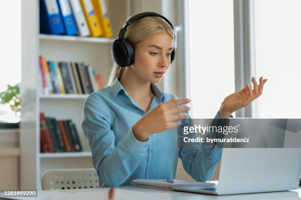 woman wearing headphones with microphone chatting online - mentoring virtual stock pictures, royalty-free photos & images