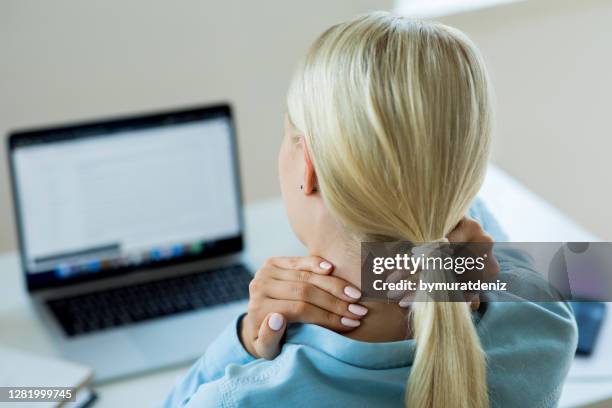 junge frauen nackenschmerzen - ergonomie stock-fotos und bilder