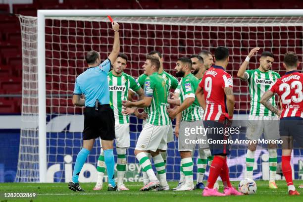 Referee Antonio Mateu Lahoz awards Martin Montoya of Real Betis a red card during the La Liga Santander match between Atletico de Madrid and Real...