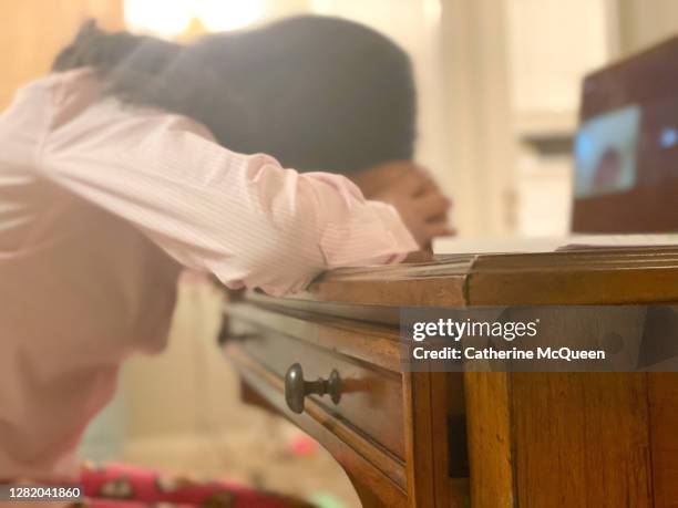 mixed-race teenage girl sitting at desk using laptop for online school rests head on stuffed animal - zoom fatigue stock pictures, royalty-free photos & images