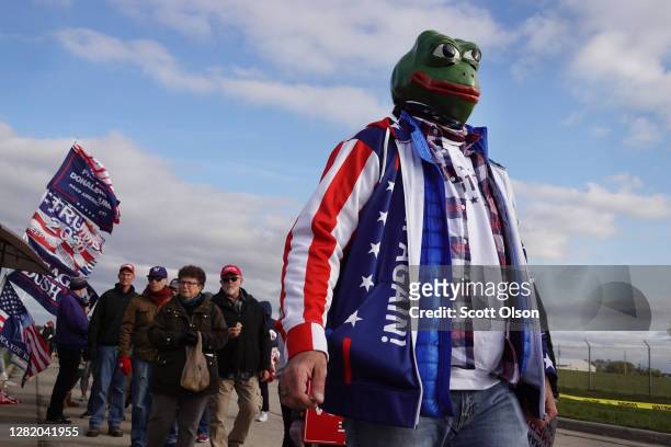 Supporters of President Donald Trump wait in line as they arrive for a campaign rally at the Waukesha County Airport on October 24, 2020 in Waukesha,...