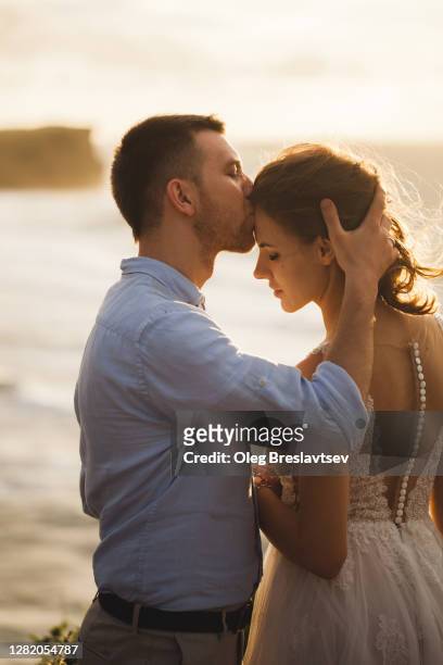 close up sunshine portrait of young couple tenderly kissing at sunset - silhouette married stock pictures, royalty-free photos & images
