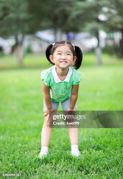 cute little girl on the lawn - hand on knee stock pictures, royalty-free photos & images