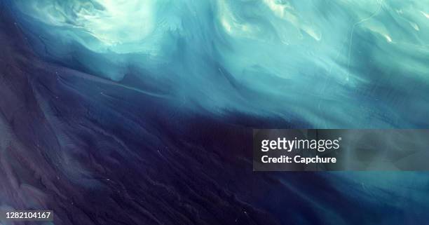 aerial downward shot of ocean currents. - tide foto e immagini stock