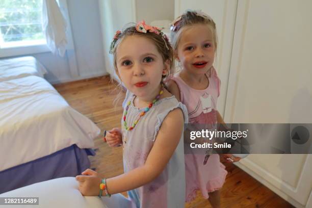two attentive young girls dressed in jewellery - 2 peas in a pod stock pictures, royalty-free photos & images