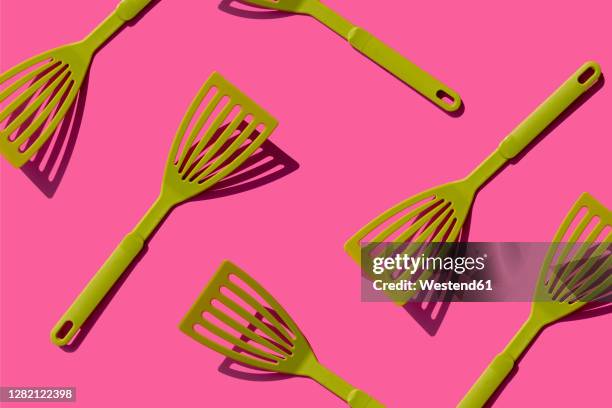 pattern of green spatulas against pink background - spatula stock pictures, royalty-free photos & images