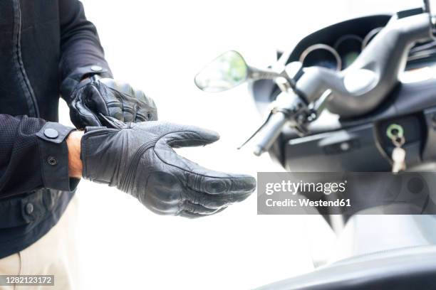 hands of biker putting on protective gloves - leather glove bildbanksfoton och bilder