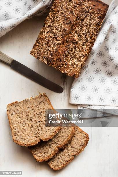 homemade loaf of buckwheat bread kept on cutting board - boekweit stockfoto's en -beelden