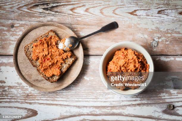 paprika and sesame spread on slice of bread at table - spread stock-fotos und bilder