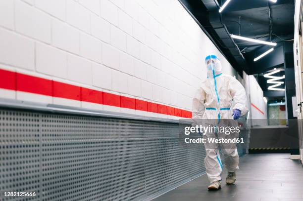 man walking with face shield in corridor at hospital - roupa protetora imagens e fotografias de stock
