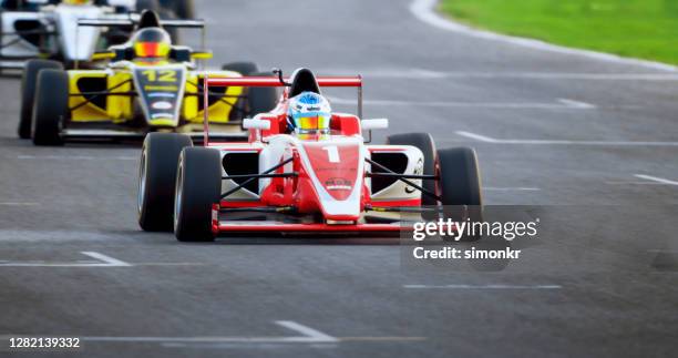 pilotos conduciendo coches de carreras - carrera de coches fotografías e imágenes de stock