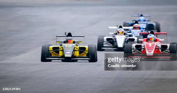drivers driving racing cars - driving course stock pictures, royalty-free photos & images