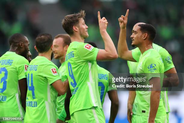 Wout Weghorst of VfL Wolfsburg celebrates with teammates after scoring his team's first goal during the Bundesliga match between VfL Wolfsburg and...