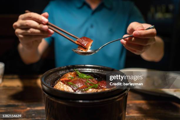 asian man eating dongpo pork in restaurant - caramel block stock pictures, royalty-free photos & images