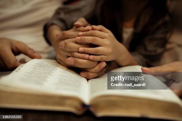ein kind, das die heilige bibel liest - praying church stock-fotos und bilder