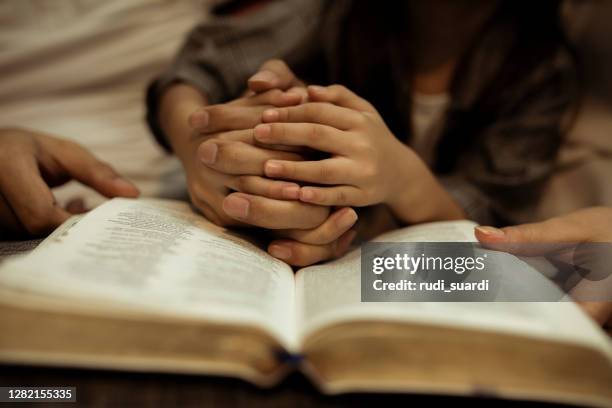 a kid reading the holy bible - children praying stock pictures, royalty-free photos & images