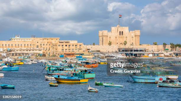 boats in front of citadel of qaitbay, alexandria, egypt - alexandria egypt stock pictures, royalty-free photos & images