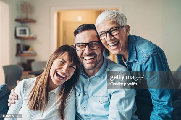 verticale d’une femme mûre heureuse avec son fils adulte et sa belle-fille - famille avec des lunettes de vue photos et images de collection