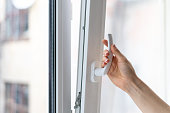 Woman opening pvc window with double glazing