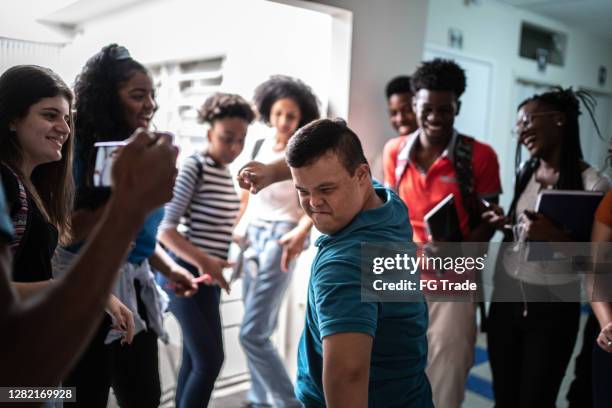 speciale behoeften student dansen in de universiteit gang - reünie sociaal stockfoto's en -beelden