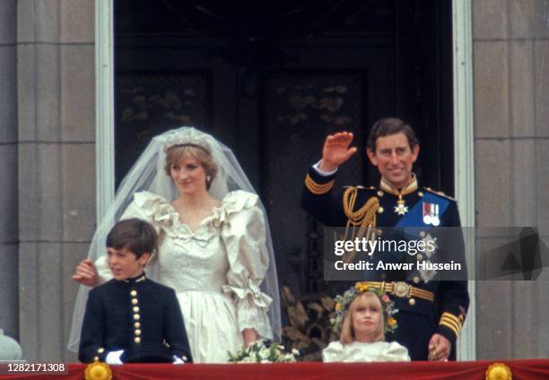 Prince Charles, Prince of Wales and Diana, Princess of Wales, whose wedding dress was designed by David and Elizabeth Emanuel, wave from the balcony...