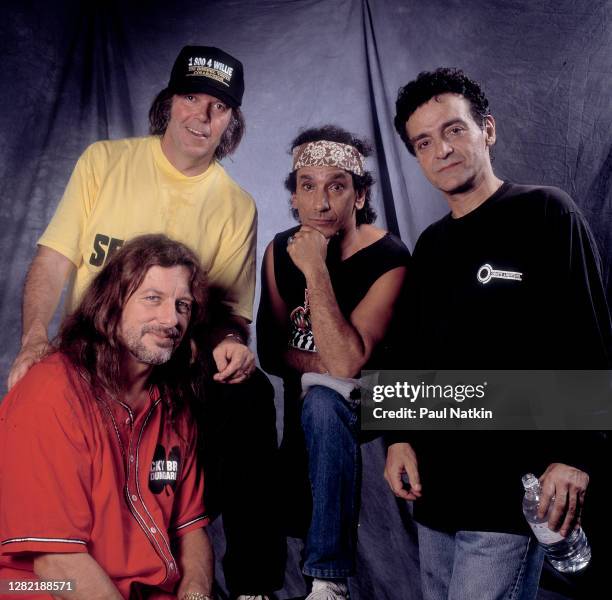 Canadian Folk and Rock musician Neil Young and members of the band Crazy Horse pose together backstage during the Farm Aid benefit concert at the New...