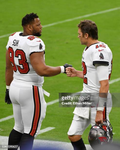 Defensive end Ndamukong Suh of the Tampa Bay Buccaneers greets quarterback Tom Brady during warmups before the team's game against the Las Vegas...