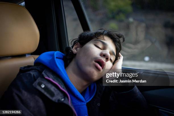 teenage boy falling asleep during car travel - sleeping in car stock pictures, royalty-free photos & images