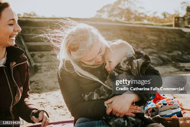 worried little boy has into his mother, as she hugs him back tightly - tímido imagens e fotografias de stock