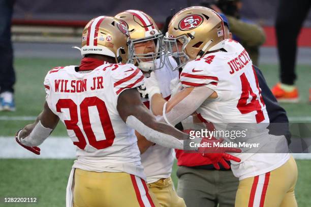Kyle Juszczyk of the San Francisco 49ers celebrates his touchdown against the New England Patriots with Jeff Wilson Jr. #30 and George Kittle during...