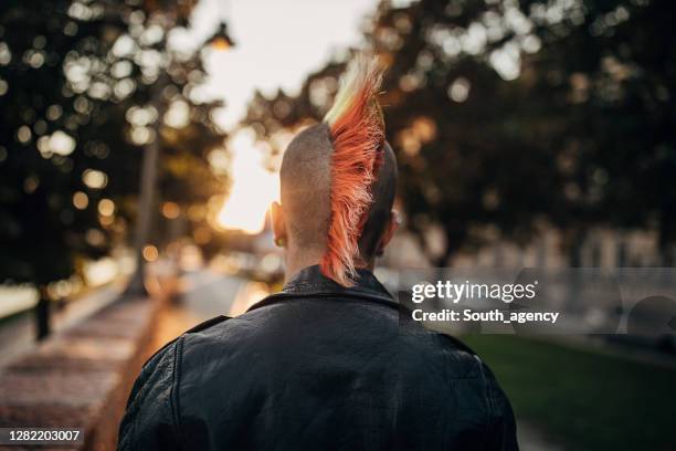 personne punk mâle avec mohawk teint restant sur la rue dans la ville - coiffure punk photos et images de collection