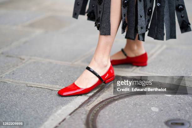 Natalia Verza wears red leather shiny Prada flat shoes, on October 12, 2020 in Paris, France.
