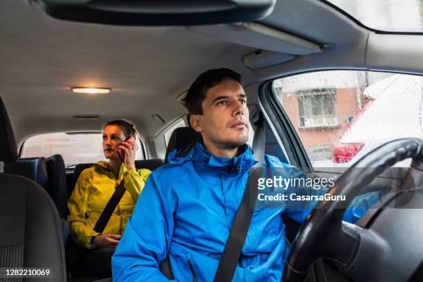 taxifahrt während coronavirus-krise ohne gesichtsmasken - taxi driver stock-fotos und bilder