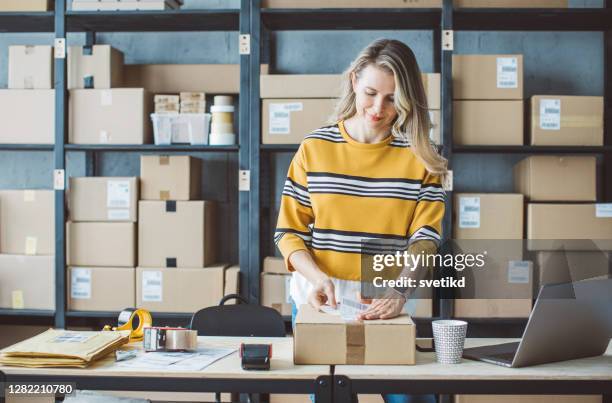 femme mûr exécutant le magasin en ligne - étiqueter photos et images de collection