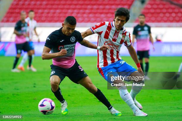 Orbelin Pineda of Cruz Azul fights for the ball with Jose Juan Macias of Chivas during the 15th round match between Chivas and Cruz Azul as part of...