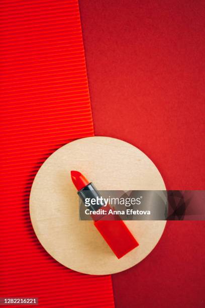 red lipstick in golden circle on rich red background - make up stock pictures, royalty-free photos & images