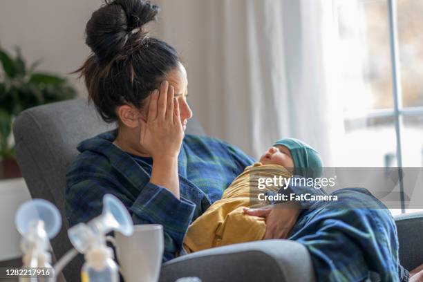 müde neue mutter hält ihr baby - stressed mum stock-fotos und bilder