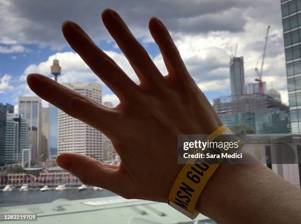 Australian resident Sara Medici takes a photograph of the view from her room with the wristband on her hand allowing her to leave the next day,...